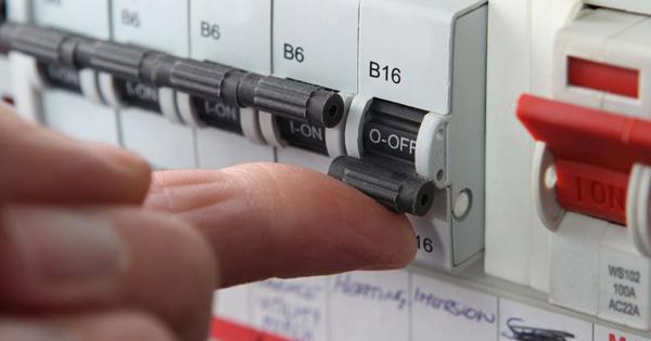 Close up of a hand pushing a switch on a fuse box