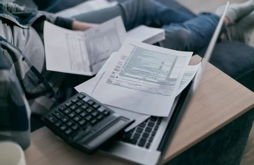 paper forms on top of laptop