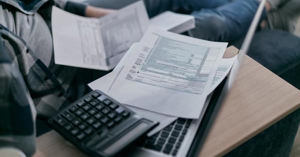 paper forms on top of laptop