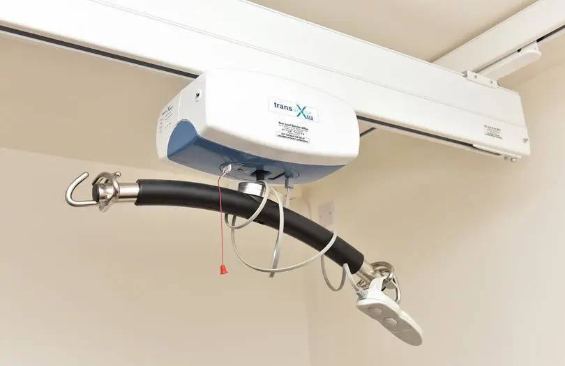 An equipment on a ceiling used to help lifting from a bed 