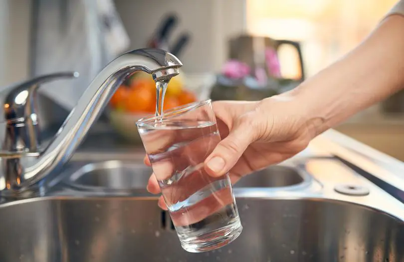 A hand filling up a glass of water from the tap